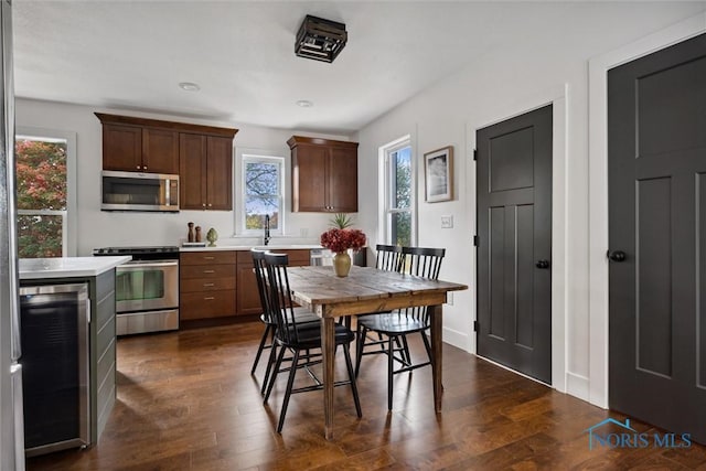 kitchen featuring wine cooler, dark hardwood / wood-style flooring, stainless steel appliances, and sink