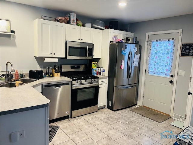 kitchen with light tile patterned flooring, stainless steel appliances, white cabinetry, and sink