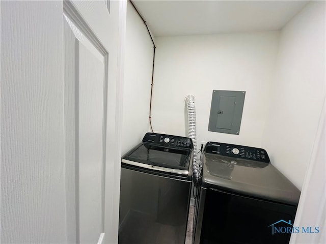 laundry room with electric panel and washing machine and clothes dryer