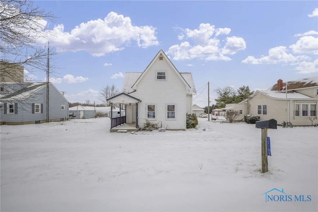 view of snow covered back of property