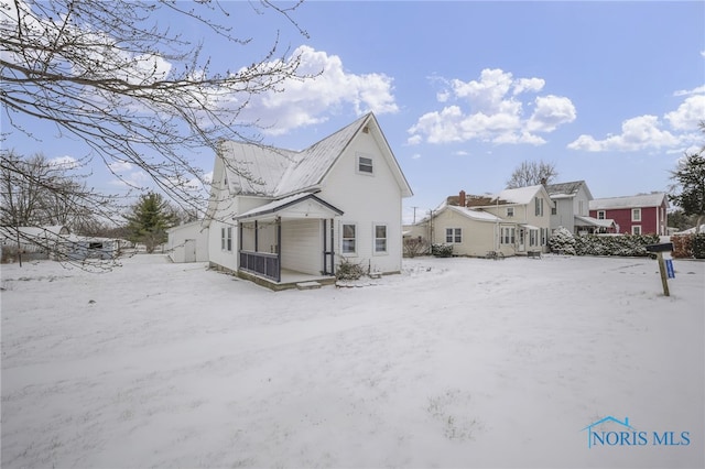 view of snow covered back of property