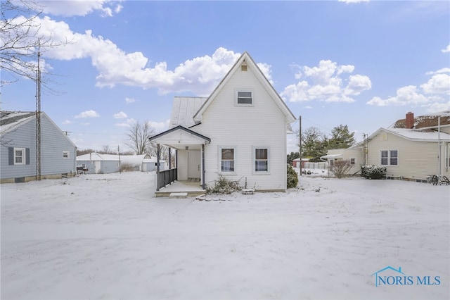 view of snow covered back of property