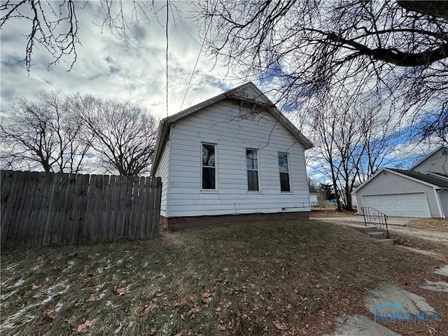 exterior space with a garage, a yard, and an outbuilding