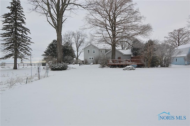 yard layered in snow featuring a wooden deck