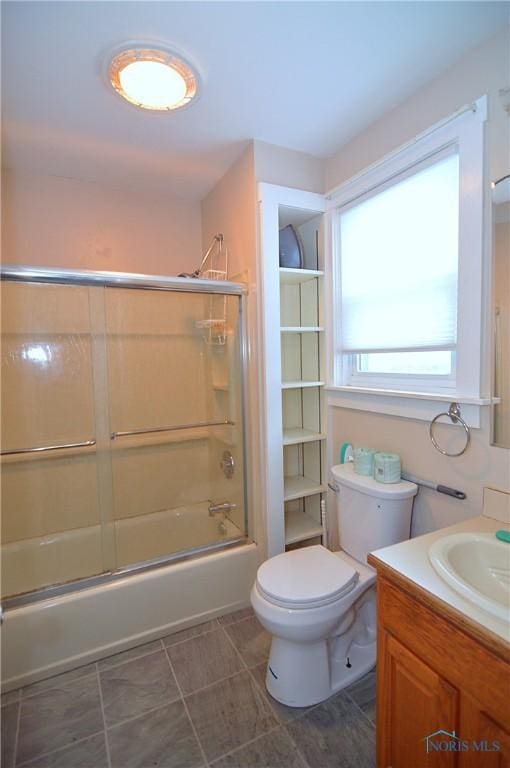 full bathroom with toilet, shower / bath combination with glass door, and vanity