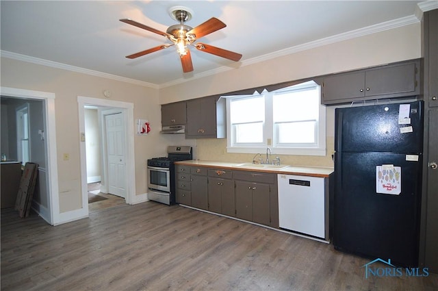 kitchen with black refrigerator, sink, stainless steel stove, white dishwasher, and crown molding