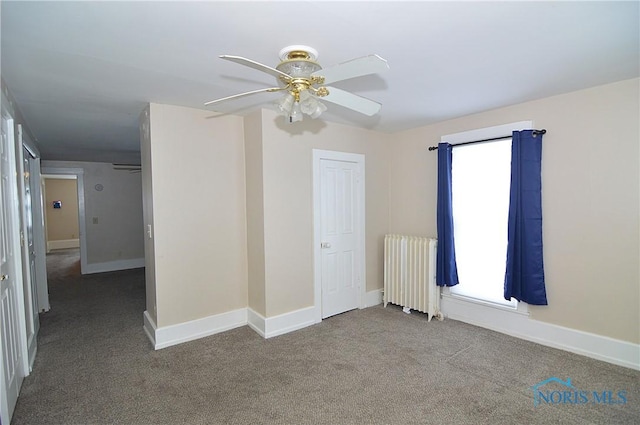 unfurnished bedroom featuring light carpet, radiator, and ceiling fan