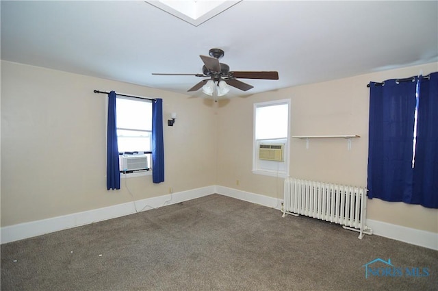 spare room featuring carpet floors, cooling unit, radiator heating unit, and ceiling fan