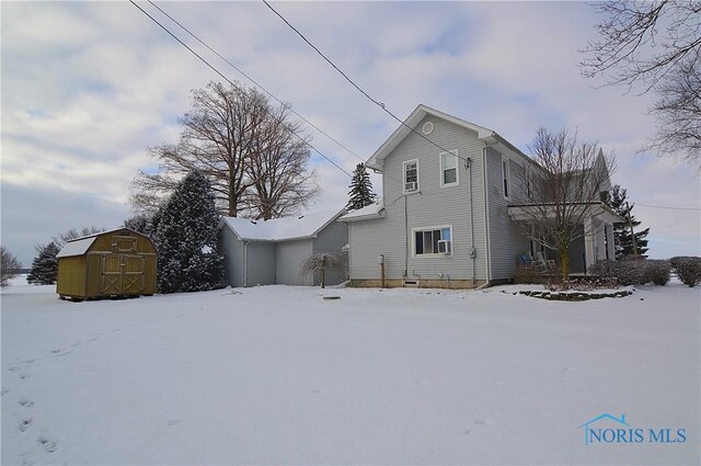 view of snowy exterior with a storage unit