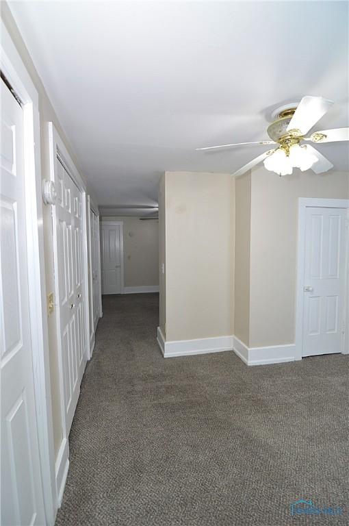 corridor featuring dark colored carpet