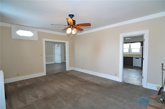 carpeted spare room with ceiling fan, ornamental molding, and sink