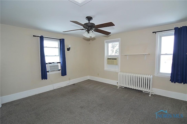 carpeted spare room with radiator heating unit, a healthy amount of sunlight, ceiling fan, and cooling unit