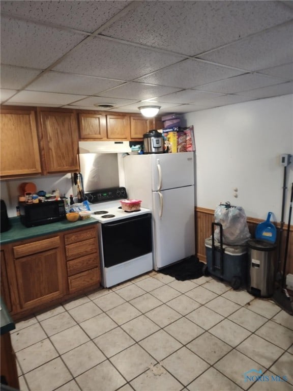 kitchen with a drop ceiling, light tile patterned floors, and white electric range oven