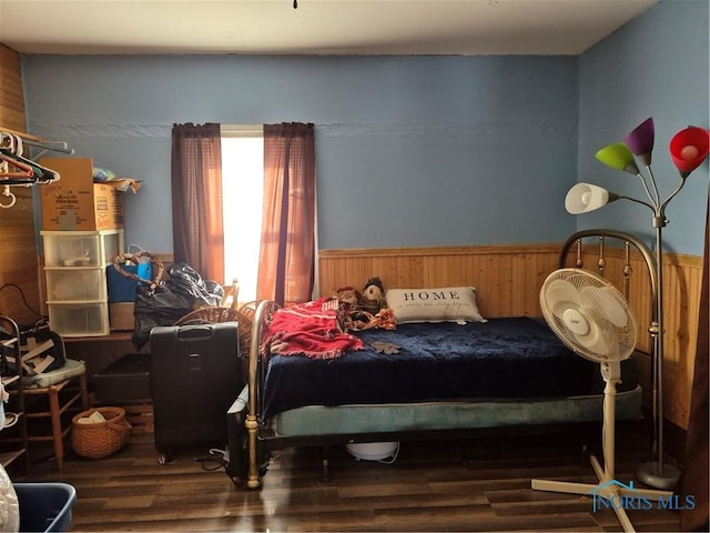 bedroom featuring wooden walls and hardwood / wood-style floors