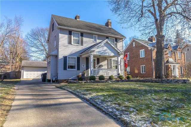 colonial house with covered porch, a garage, a front lawn, and an outdoor structure