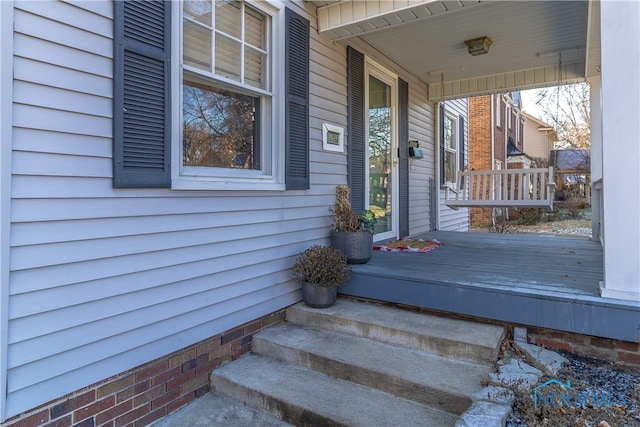 view of exterior entry featuring covered porch