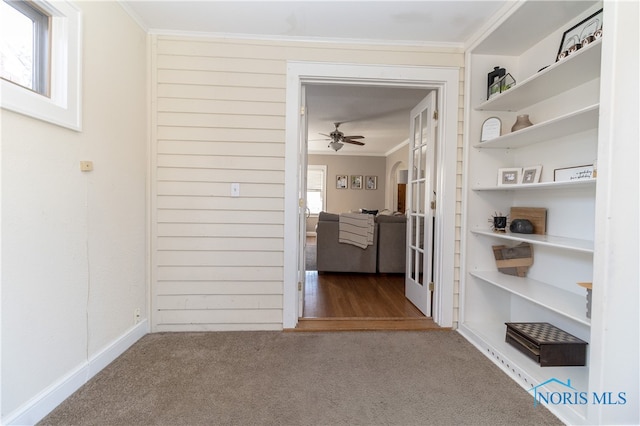 hallway with carpet flooring and crown molding