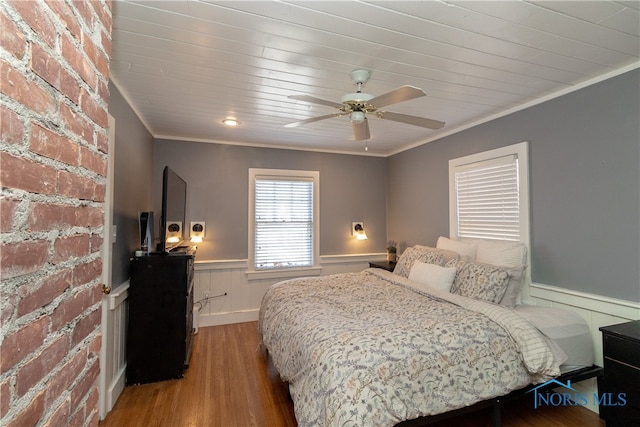 bedroom featuring wooden ceiling, ceiling fan, ornamental molding, wood-type flooring, and brick wall