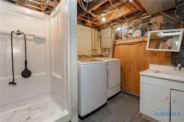 washroom with electric panel, cabinets, sink, and washer and dryer