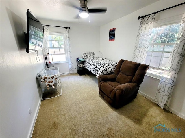 bedroom featuring multiple windows, ceiling fan, and light carpet