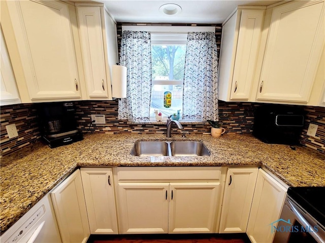 kitchen featuring decorative backsplash, white cabinets, light stone counters, and sink