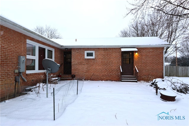 view of snow covered back of property