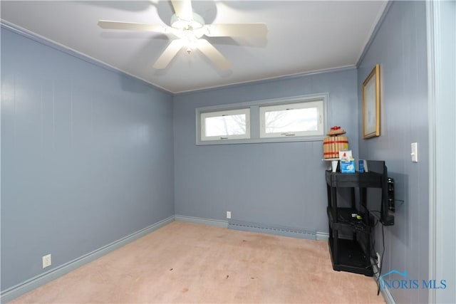 carpeted spare room featuring ceiling fan, crown molding, and a baseboard heating unit