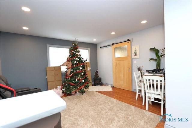 office featuring a barn door and hardwood / wood-style flooring