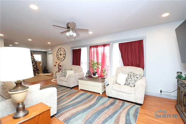 living room with ceiling fan and light hardwood / wood-style flooring