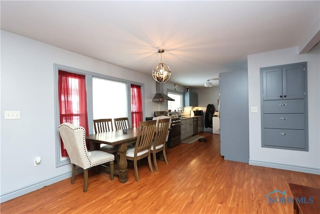 dining room featuring a notable chandelier, light hardwood / wood-style floors, and sink