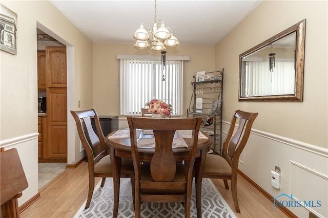 dining room featuring light wood-type flooring and a notable chandelier