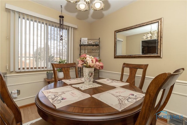 dining space with wood-type flooring and a notable chandelier