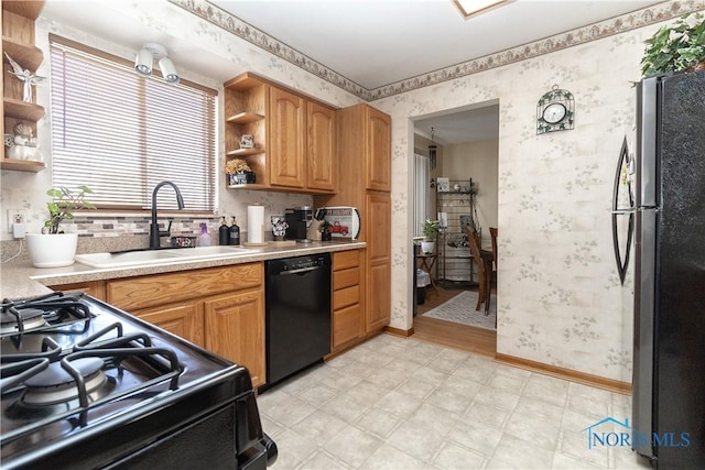 kitchen with sink, black dishwasher, gas range, and stainless steel fridge