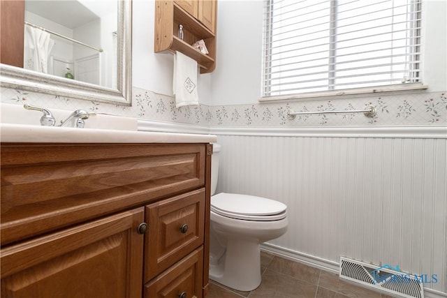 bathroom featuring toilet, tile patterned floors, and vanity