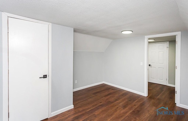 bonus room featuring dark hardwood / wood-style floors, vaulted ceiling, and a textured ceiling