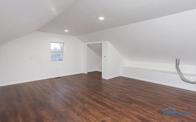 additional living space featuring dark hardwood / wood-style floors and vaulted ceiling