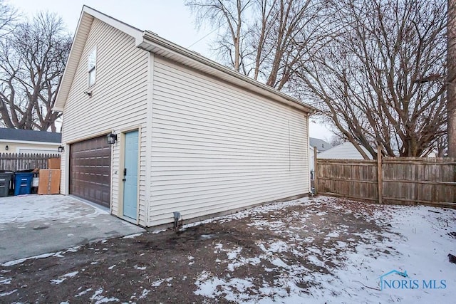 view of snow covered exterior with a garage