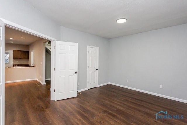 unfurnished room featuring dark wood-type flooring