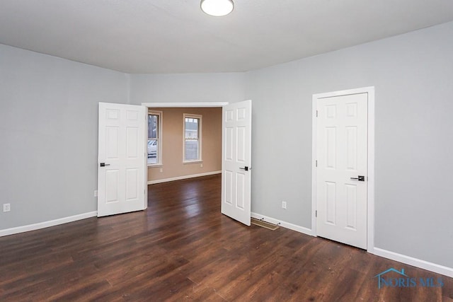 unfurnished room featuring dark hardwood / wood-style flooring