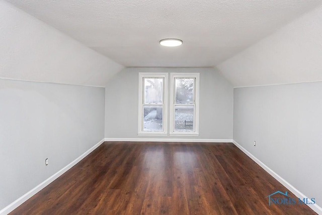 bonus room featuring vaulted ceiling, dark hardwood / wood-style floors, and a textured ceiling