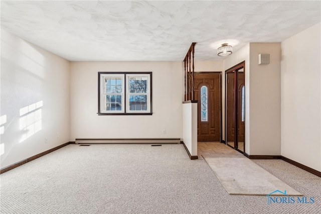 carpeted foyer with a baseboard heating unit