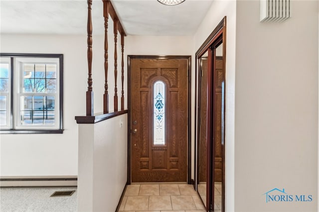 tiled foyer featuring baseboard heating