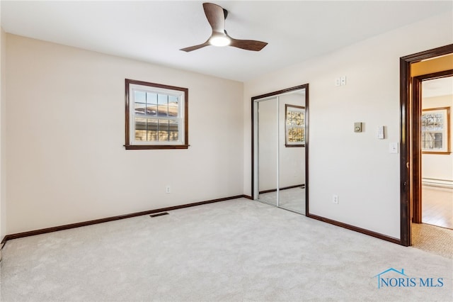 unfurnished bedroom featuring light carpet, a closet, and ceiling fan