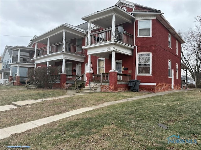 view of front of house with a porch, a balcony, and a front lawn