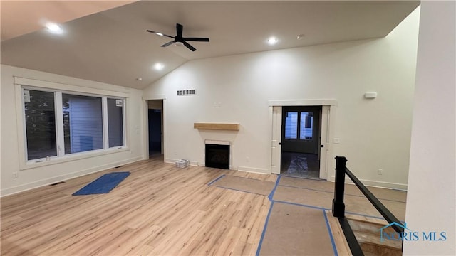 unfurnished living room with ceiling fan, high vaulted ceiling, and light wood-type flooring