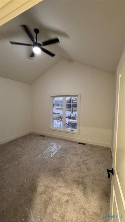 carpeted spare room with ceiling fan and lofted ceiling