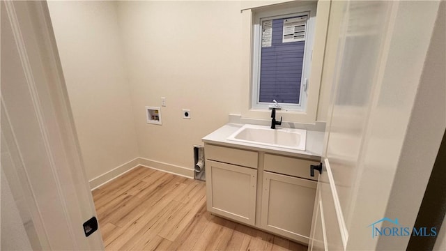 washroom with sink, cabinets, hookup for a washing machine, electric dryer hookup, and light hardwood / wood-style flooring