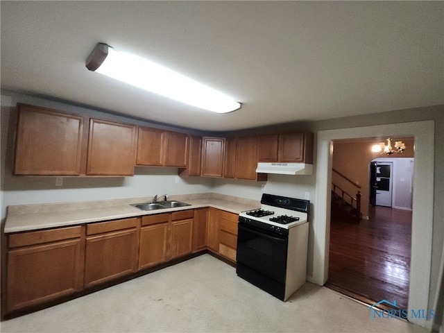 kitchen with an inviting chandelier, white range with gas cooktop, and sink