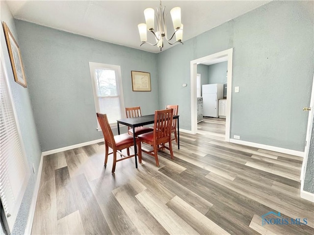 dining space featuring hardwood / wood-style floors and a chandelier