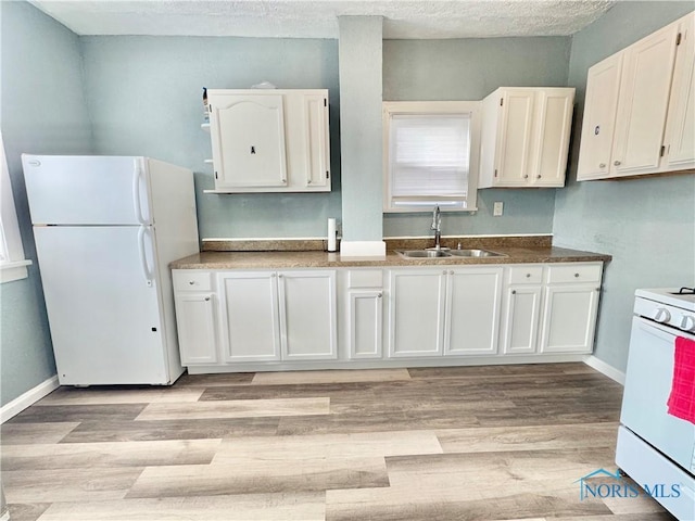 kitchen with light wood-type flooring, white appliances, white cabinetry, and sink